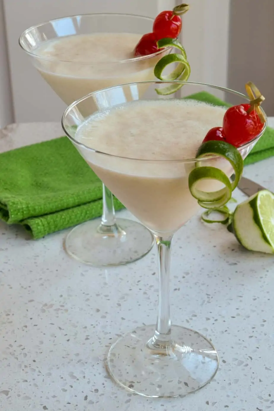 Frozen Banana Daiquiris garnished with a lime twist and a cherry. 