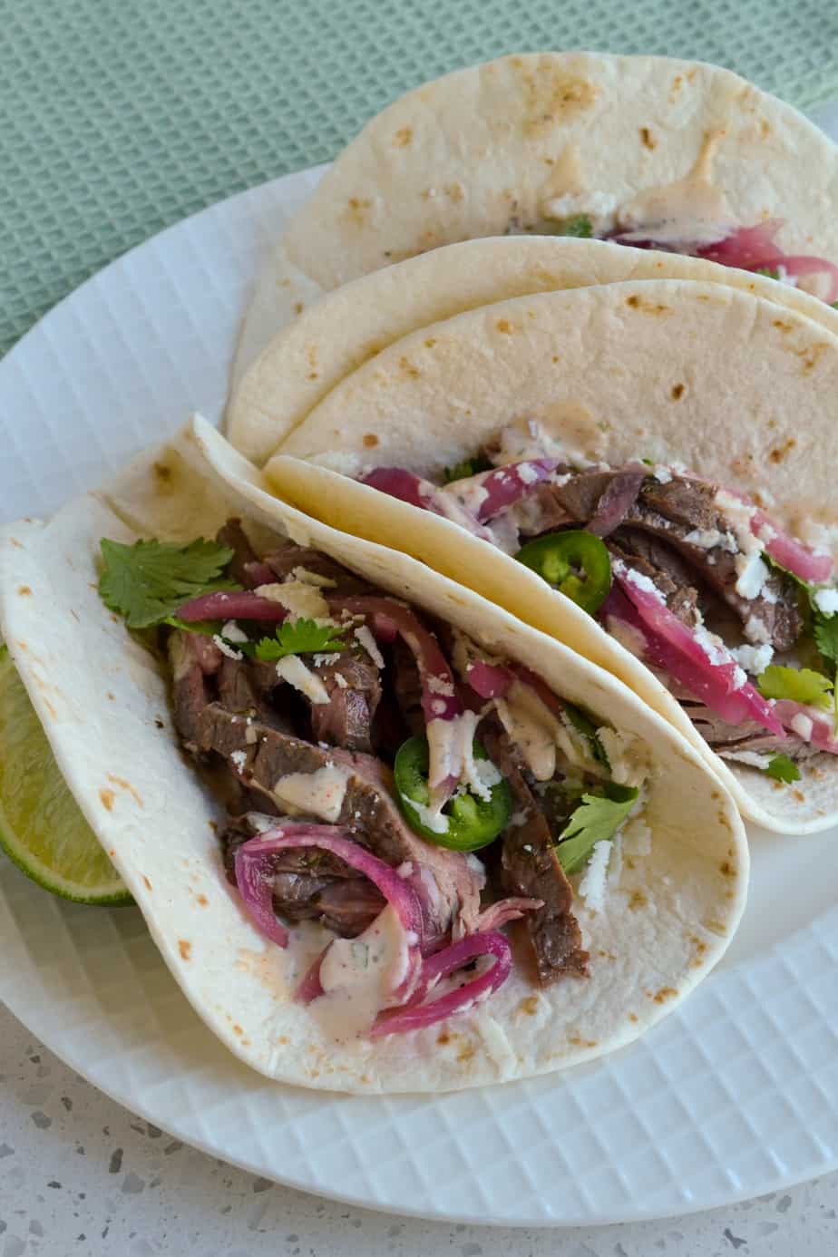 Tortillas filled with grilled steak, pickled onions, and cilantro.
