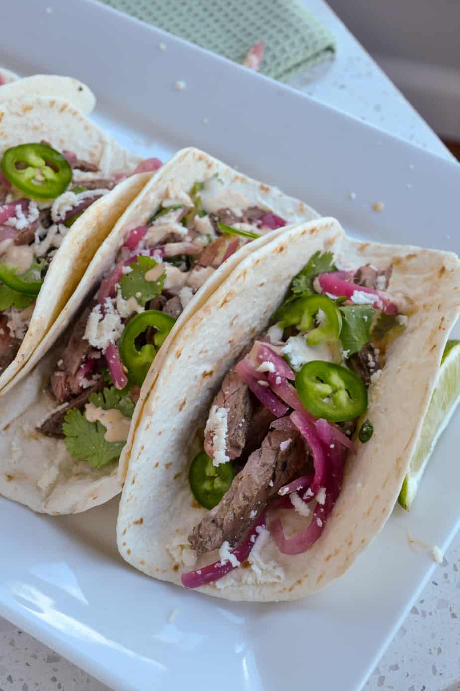 Carne asada street tacos with pickled onions and queso panela cheese.