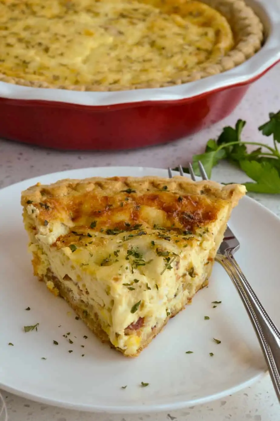 A piece of cheesy Quiche Lorraine on a plate. 