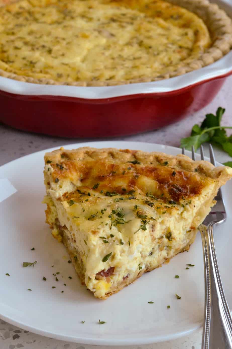 A slice of warm bacon and gruyere cheese quiche. 
