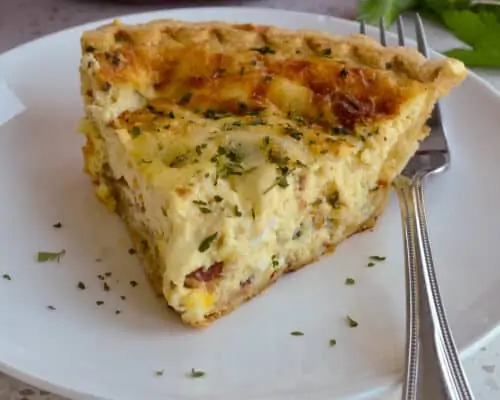 A slice of quiche on a plate