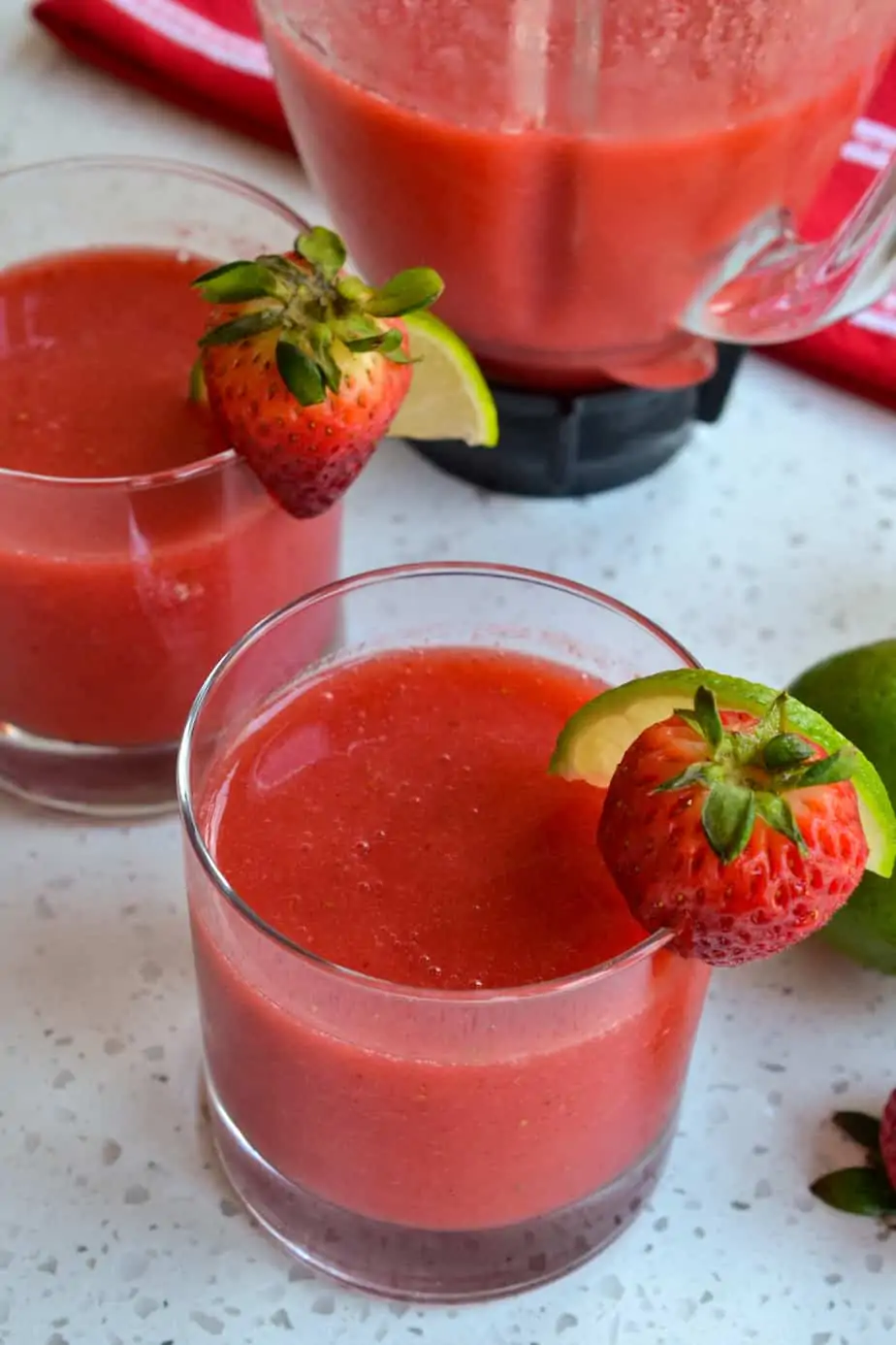 Glasses and blender full of refreshing strawberry daiquiris. 