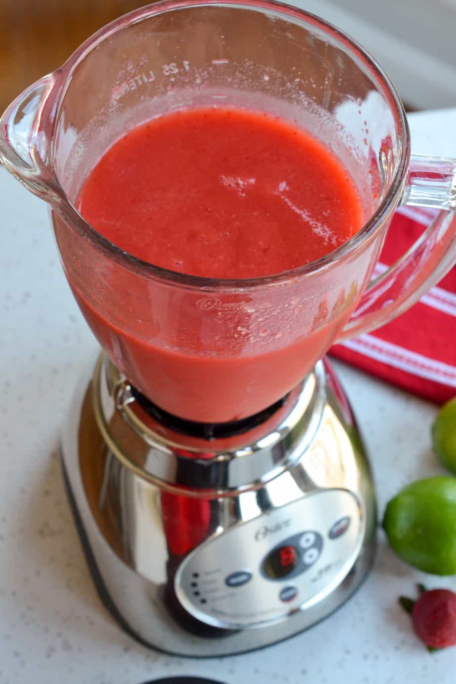 A blender full of strawberries, rum, simple syrup and lime juice. 