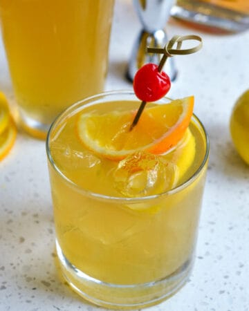 Whiskey Sour with orange and cherry garnish