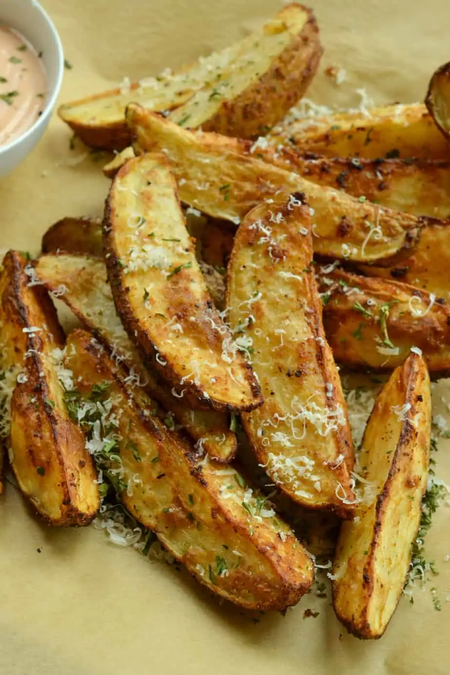Crispy air fried potato wedges sprinkled with Parmesan cheese and parsley