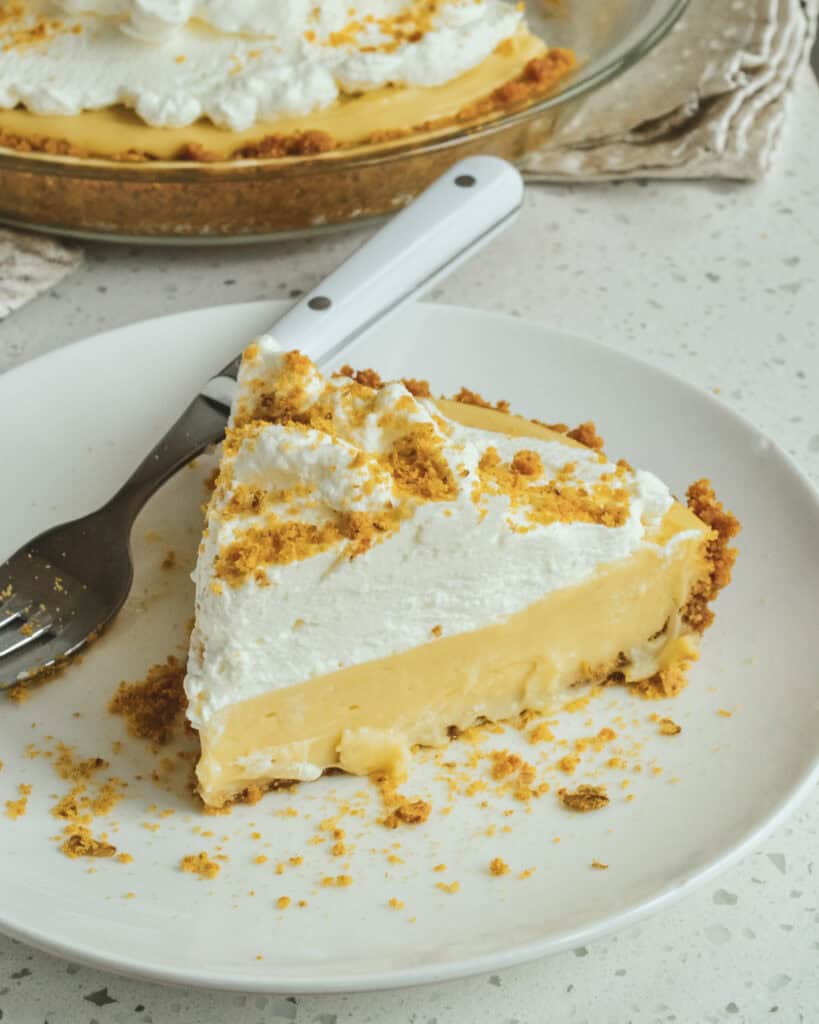 A slice of butterscotch pie on a plate with a fork.