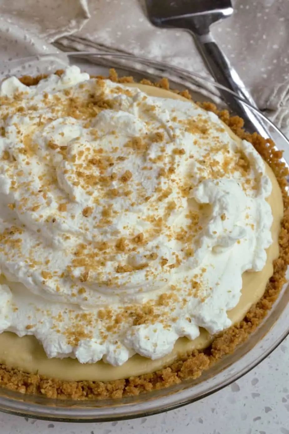 A creamy butterscotch pie topped with whipped cream and crushed breakfast biscuits