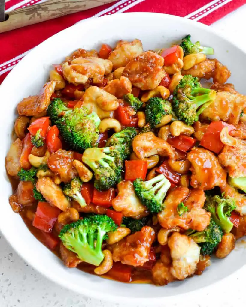 Cashew Chicken combines crispy pan fried chicken breast pieces with sweet red bell pepper, tender crisp broccoli, and roasted cashews in a slightly spicy sweet and tangy sauce. 