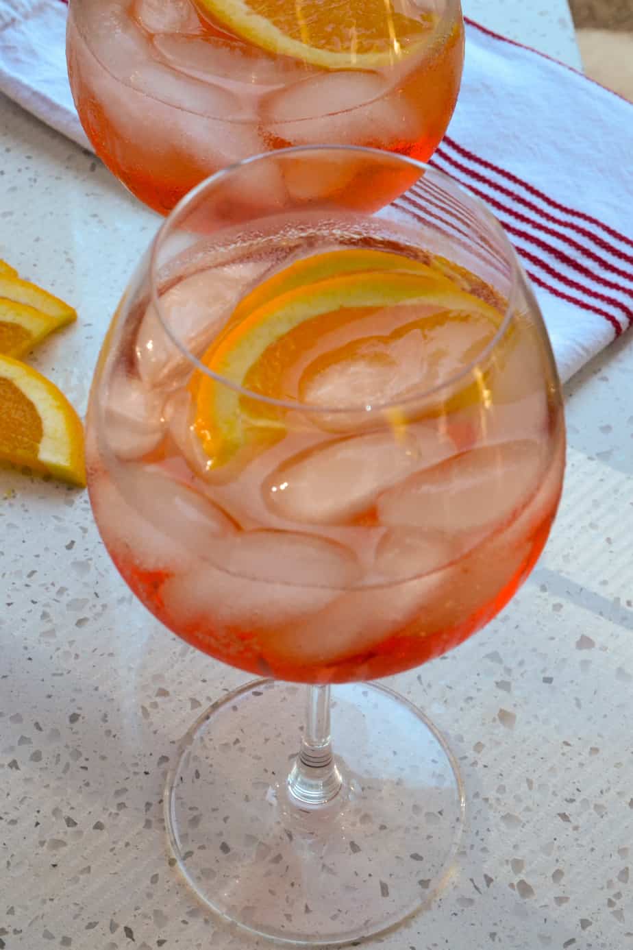 Aperol spritz cocktail over ice with orange slices. 