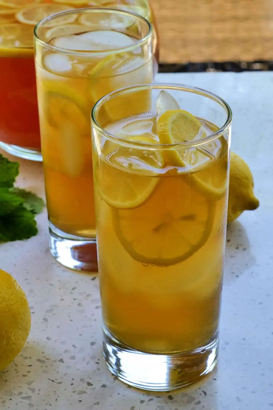 Two ice cold glasses of Arnold Palmer Tea with fresh lemon slices. 