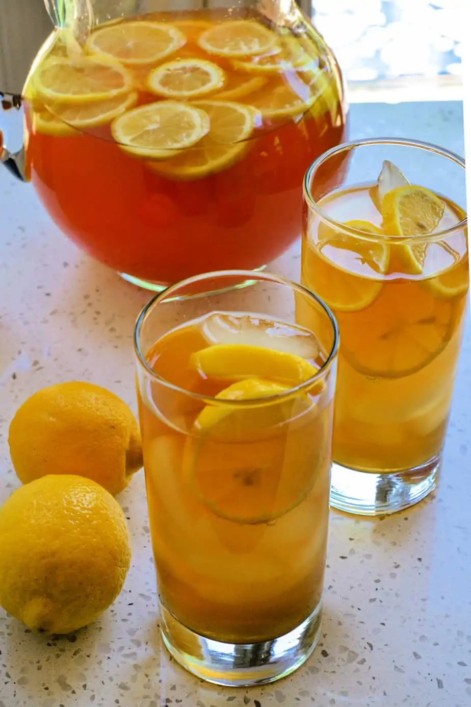 Two glasses and a pitcher full of Arnold Palmer tea. 