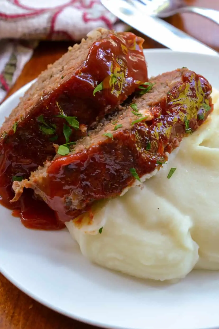 Sliced meatloaf on top of mashed potatoes.