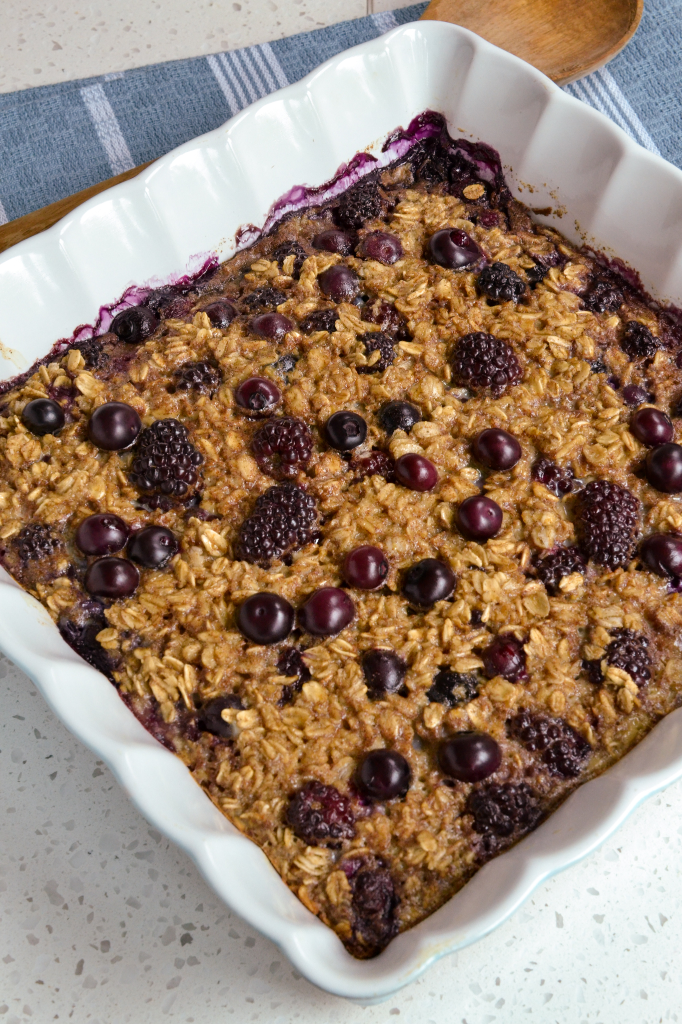 A casserole full of baked oatmeal with blackberries and blueberries. 