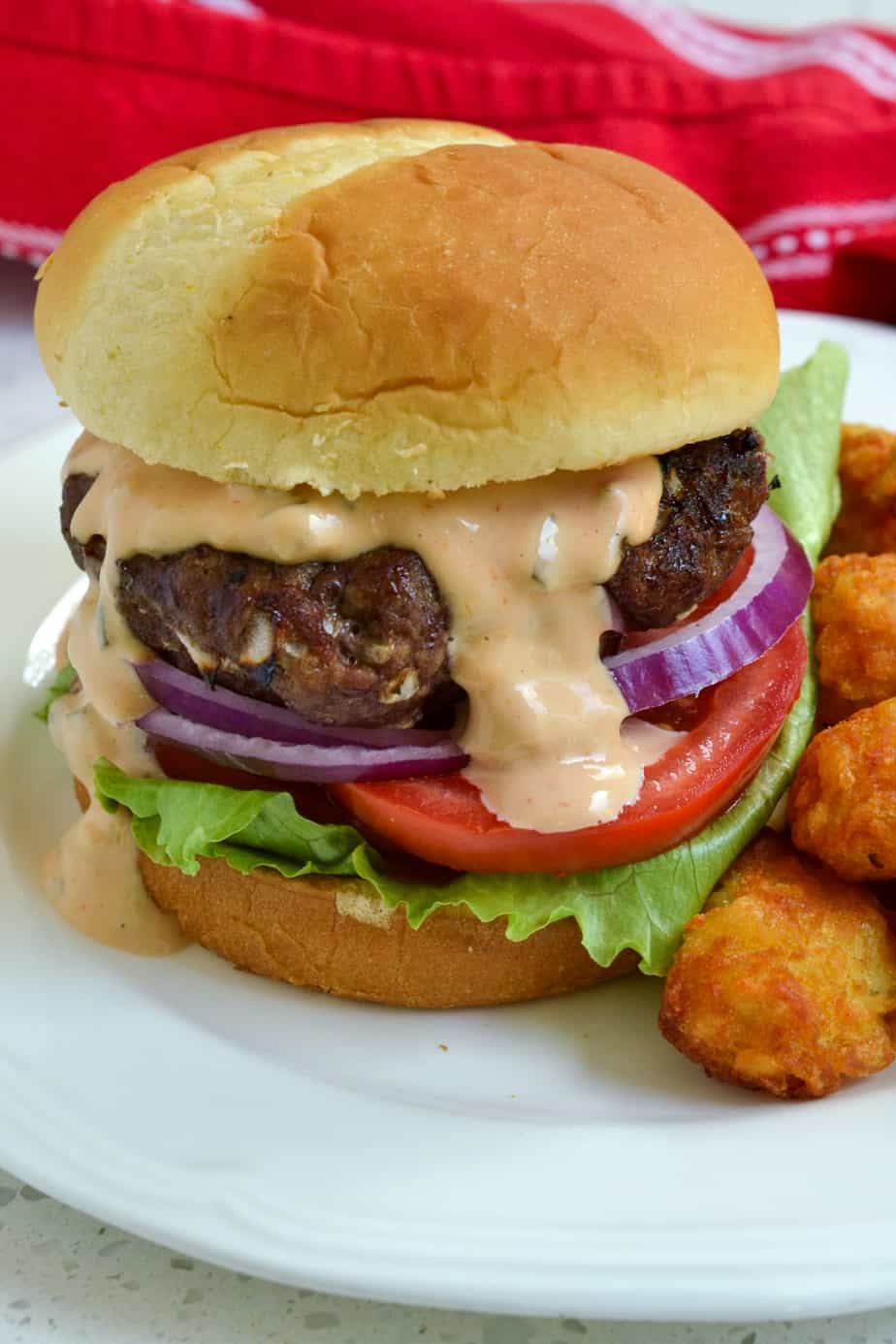 A juicy grilled burger with tomato and lettuce. 