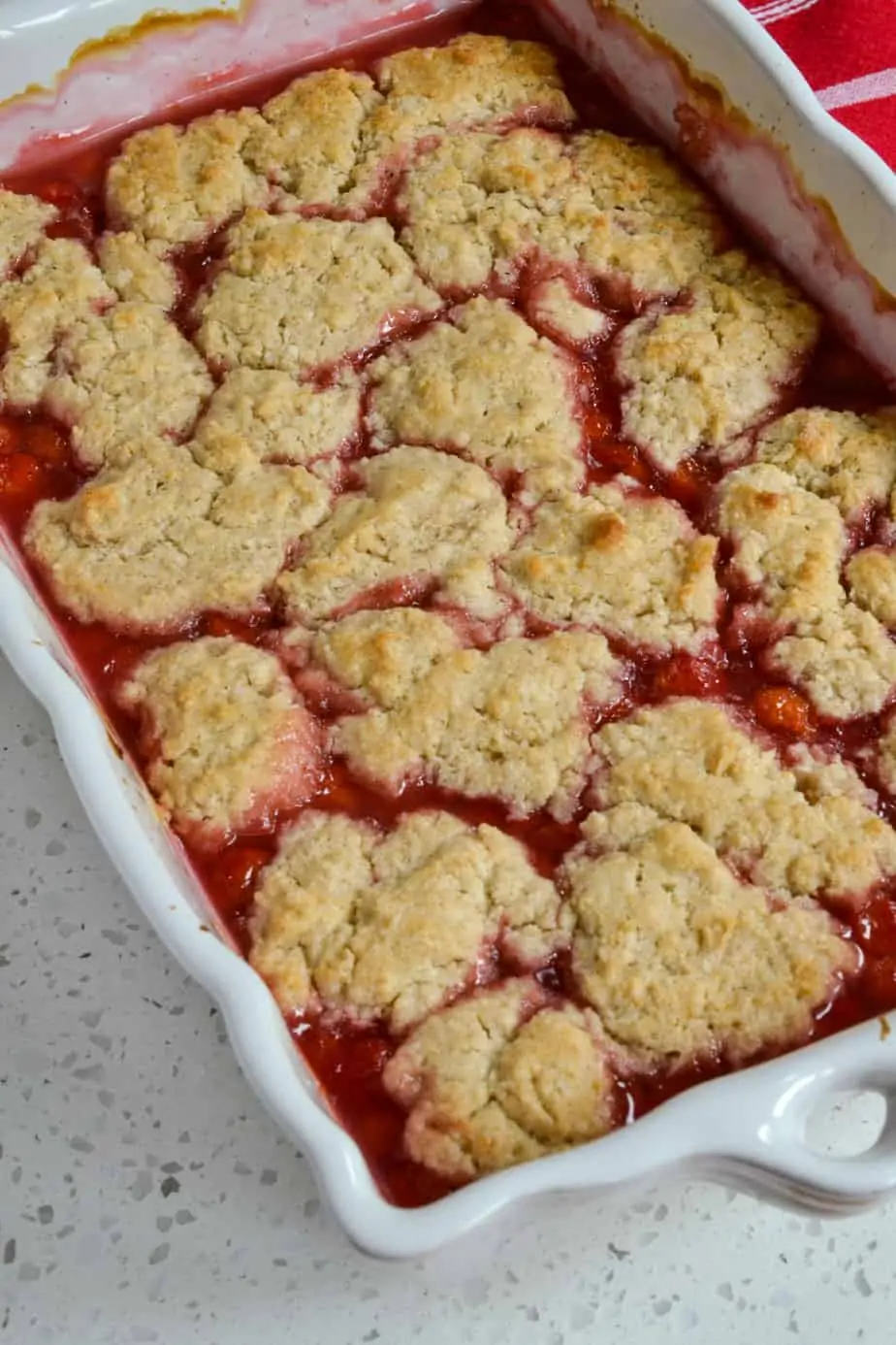 A casserole dish full of fresh baked cherry cobbler. 