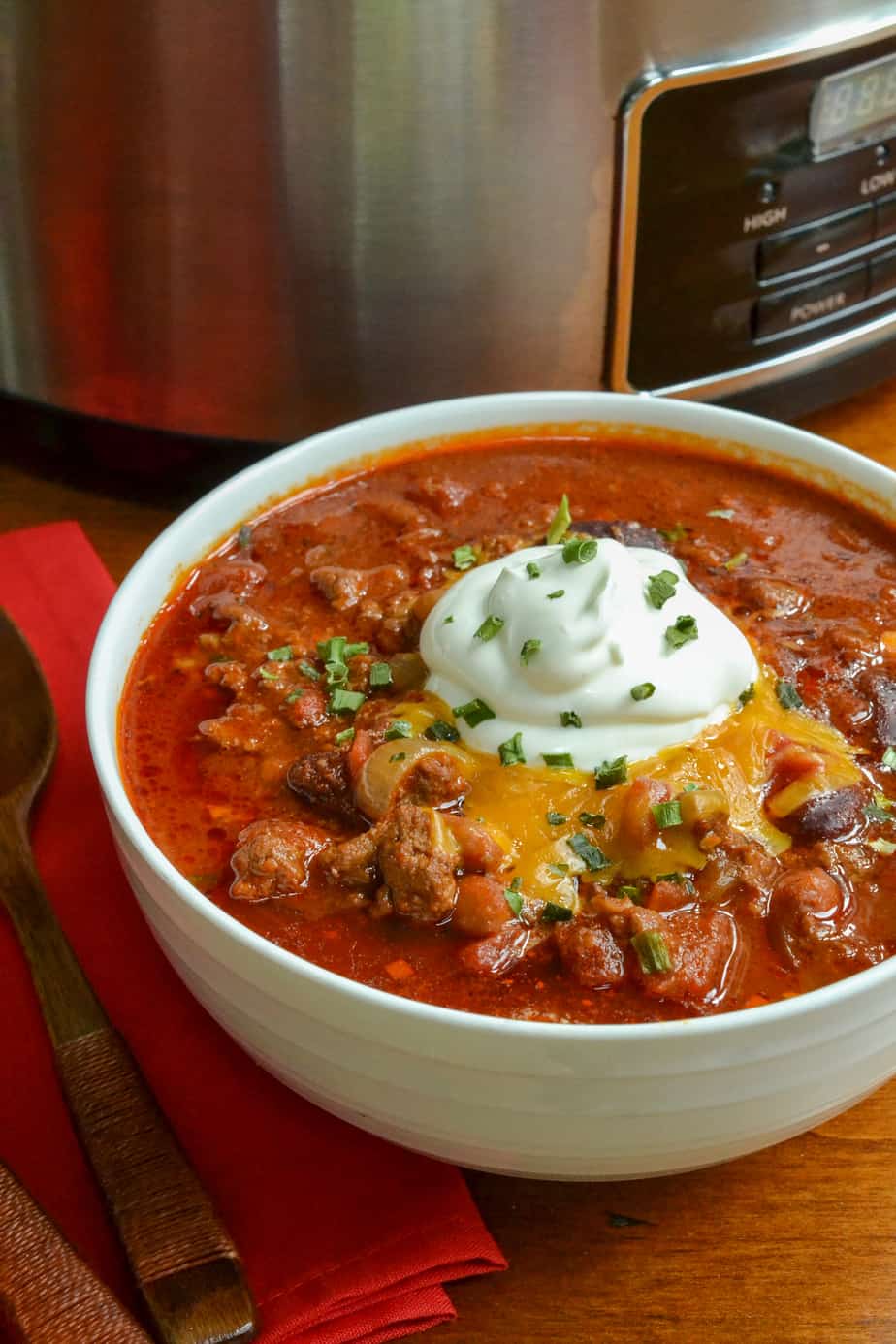 A bowl full of chili topped with sour cream and cheese. 