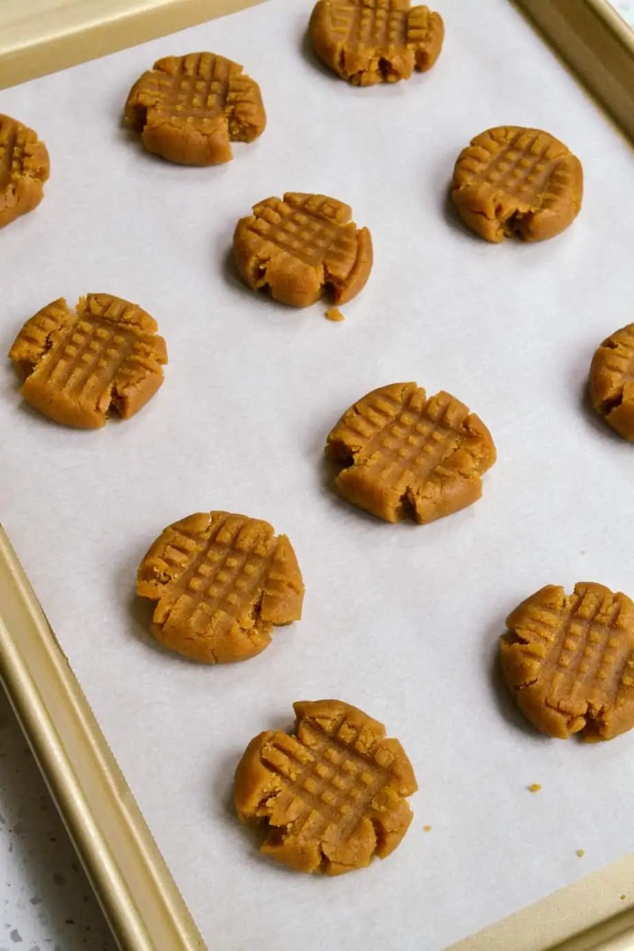 Peanut butter cookie dough prepped on a baking sheet. 