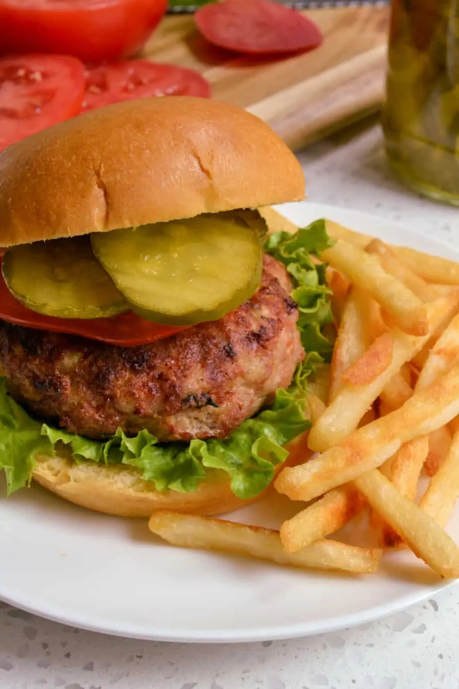 Turkey burger with lettuce, tomato, and pickles. 