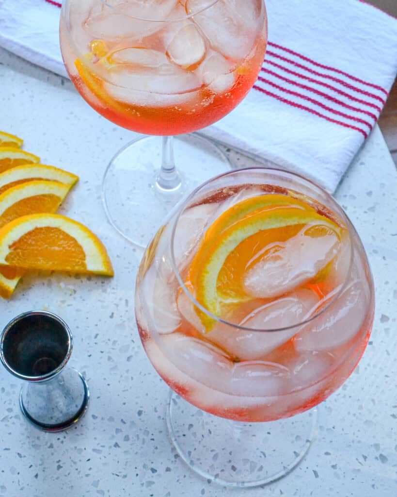 An overhead view of two glasses full of aperol spritz. 