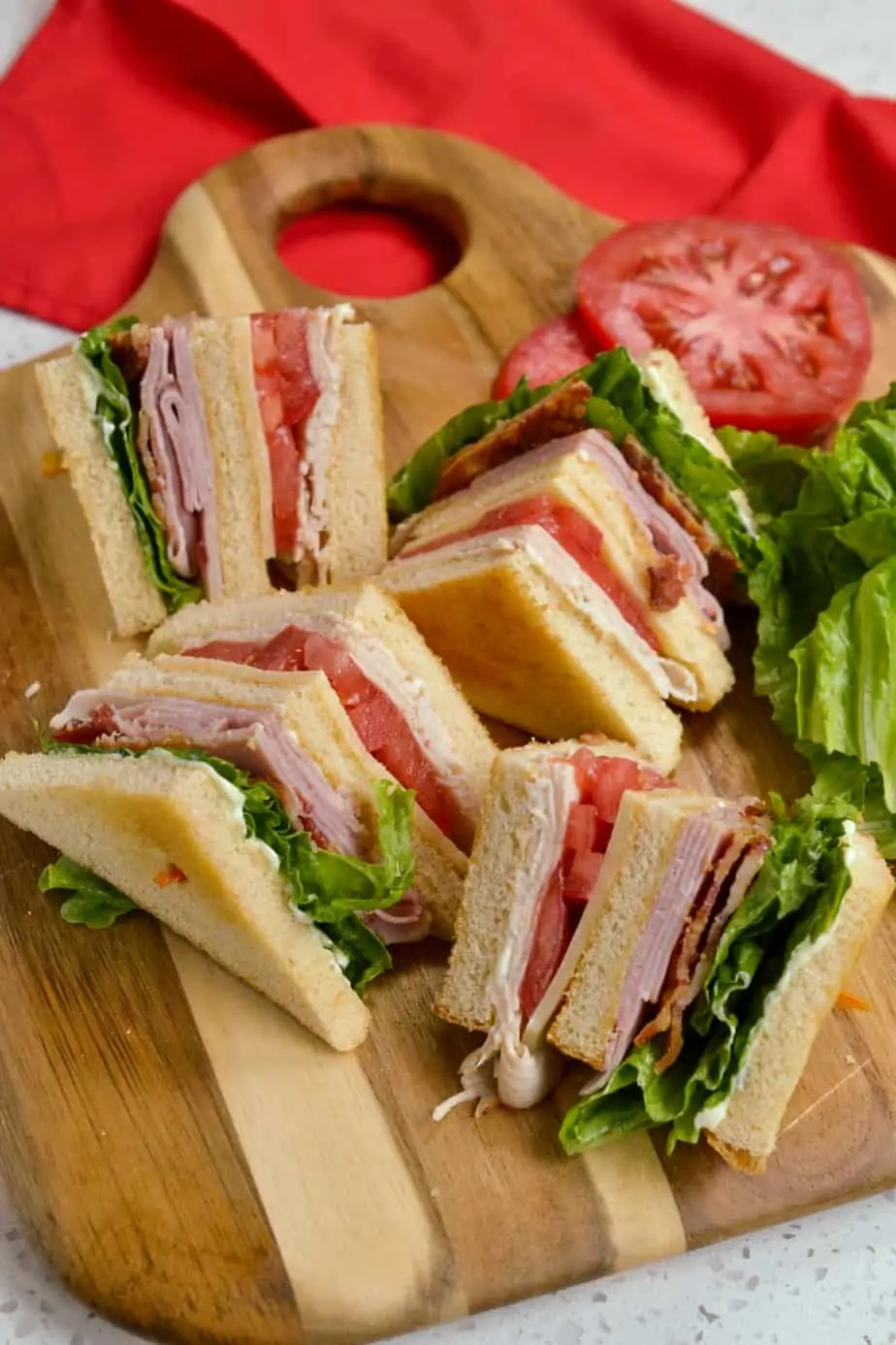 A classic club sandwich quartered on a cutting board. 