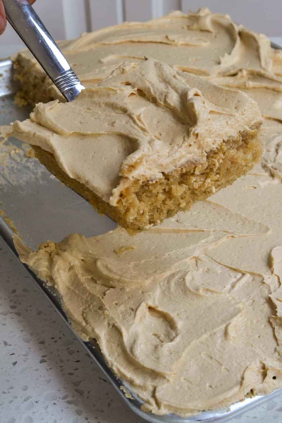 A slice of peanut butter cake with creamy peanut butter frosting.