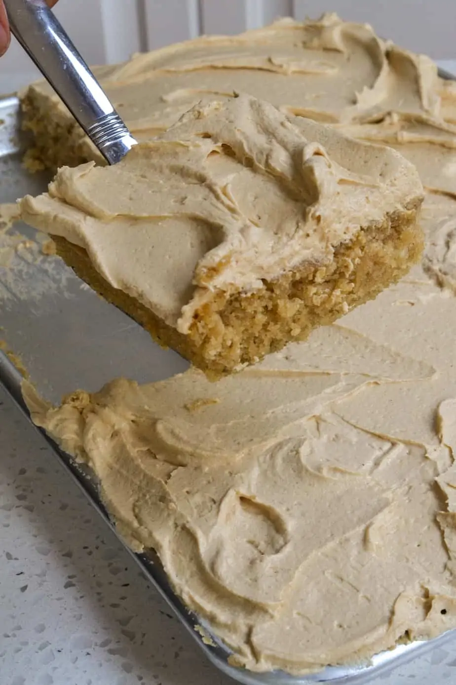 A slice of peanut butter cake with creamy peanut butter frosting. 