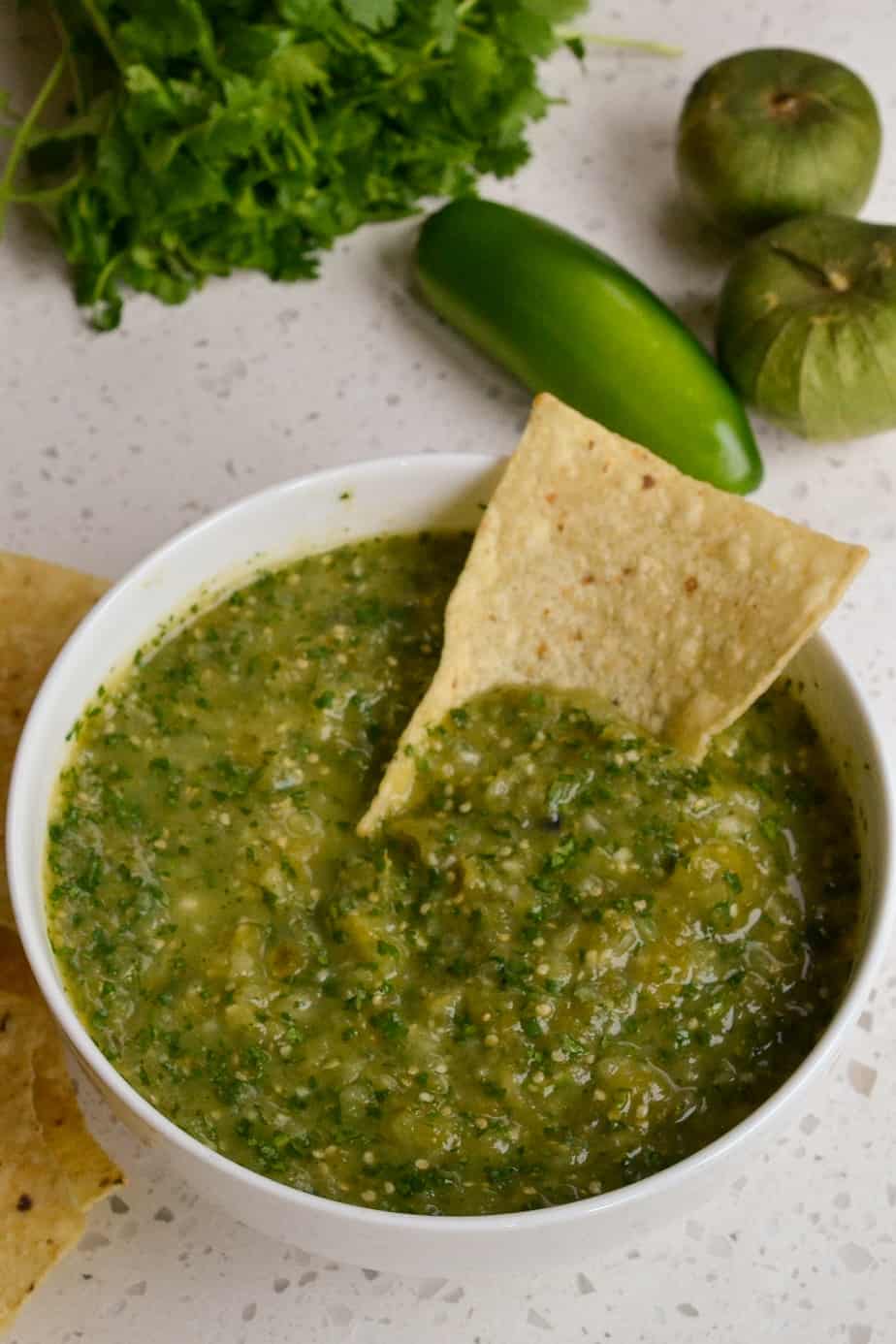 A chip dipped in fresh roasted homemade tomatillo salsa.