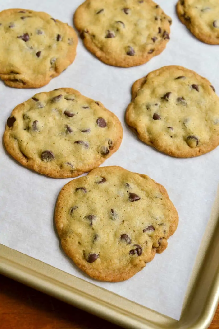 A baking sheet full of crispy chocolate chip cookies. 