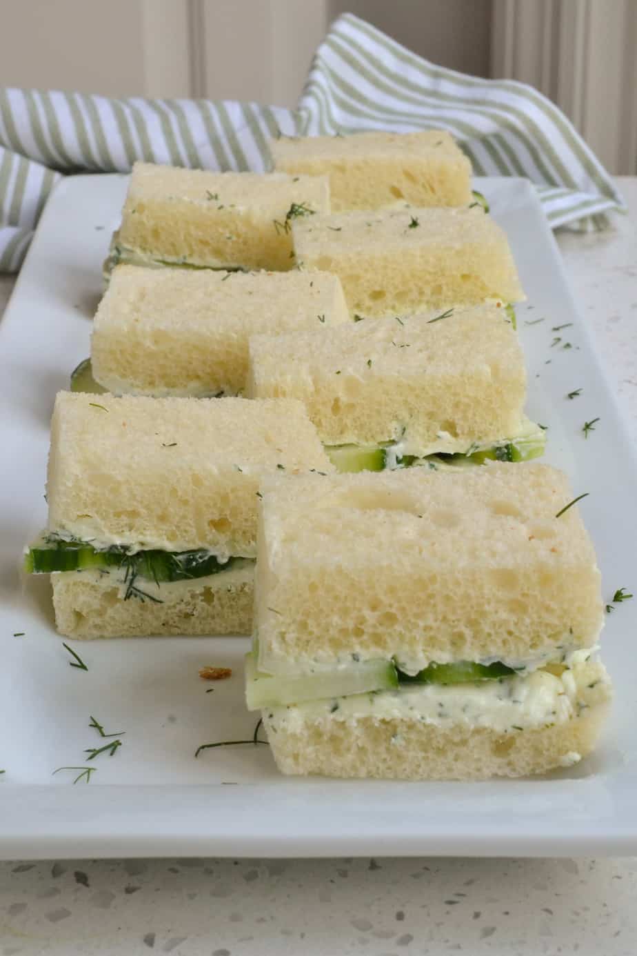 A platter full of cucumber sandwiches. 