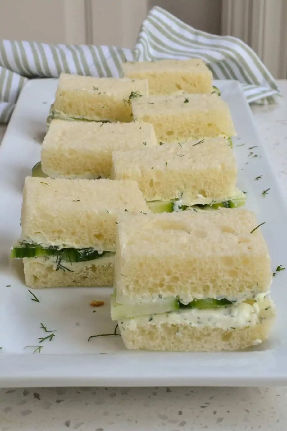 A platter full of cucumber sandwiches. 