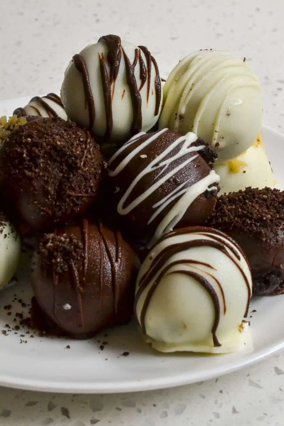 Delectable Oreo Truffles are made easily with a food processor and dipped in melted white and dark chocolate. 