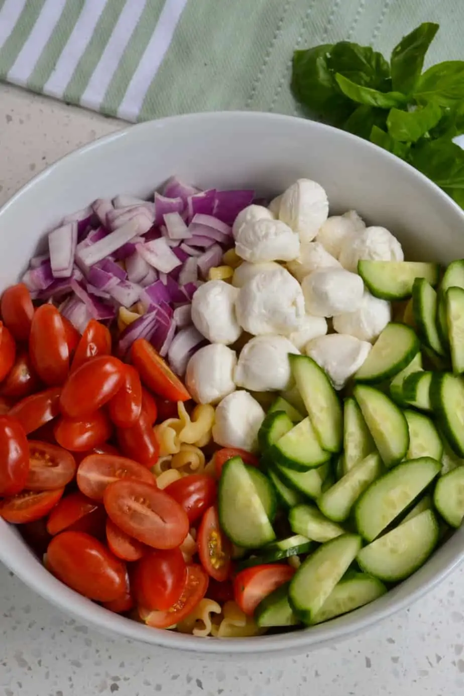 Some of the ingredients for the pasta salad in a bowl. 