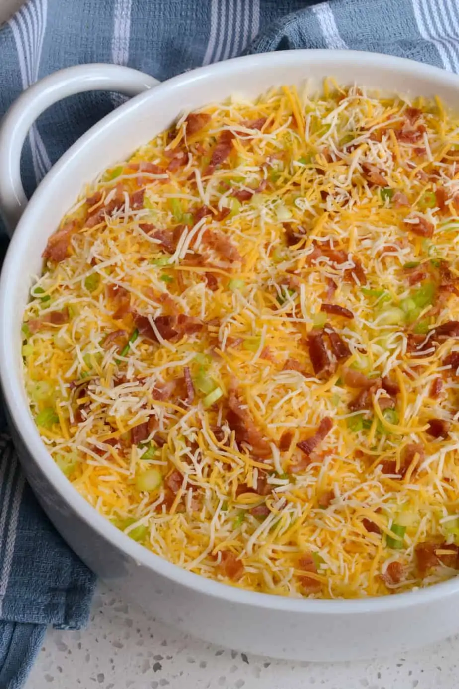 Top the twice baked potatoes with bacon, cheese, and green onions. 