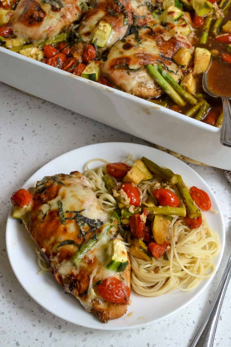 A plate full of angel hair pasta, balsamic chicken, and vegetables. 
