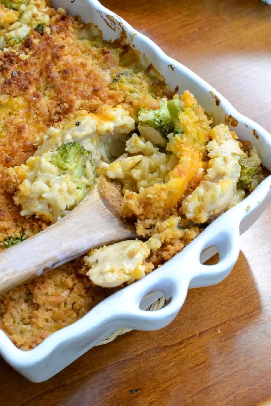 A spoon full of cheesy chicken broccoli rice casserole. 