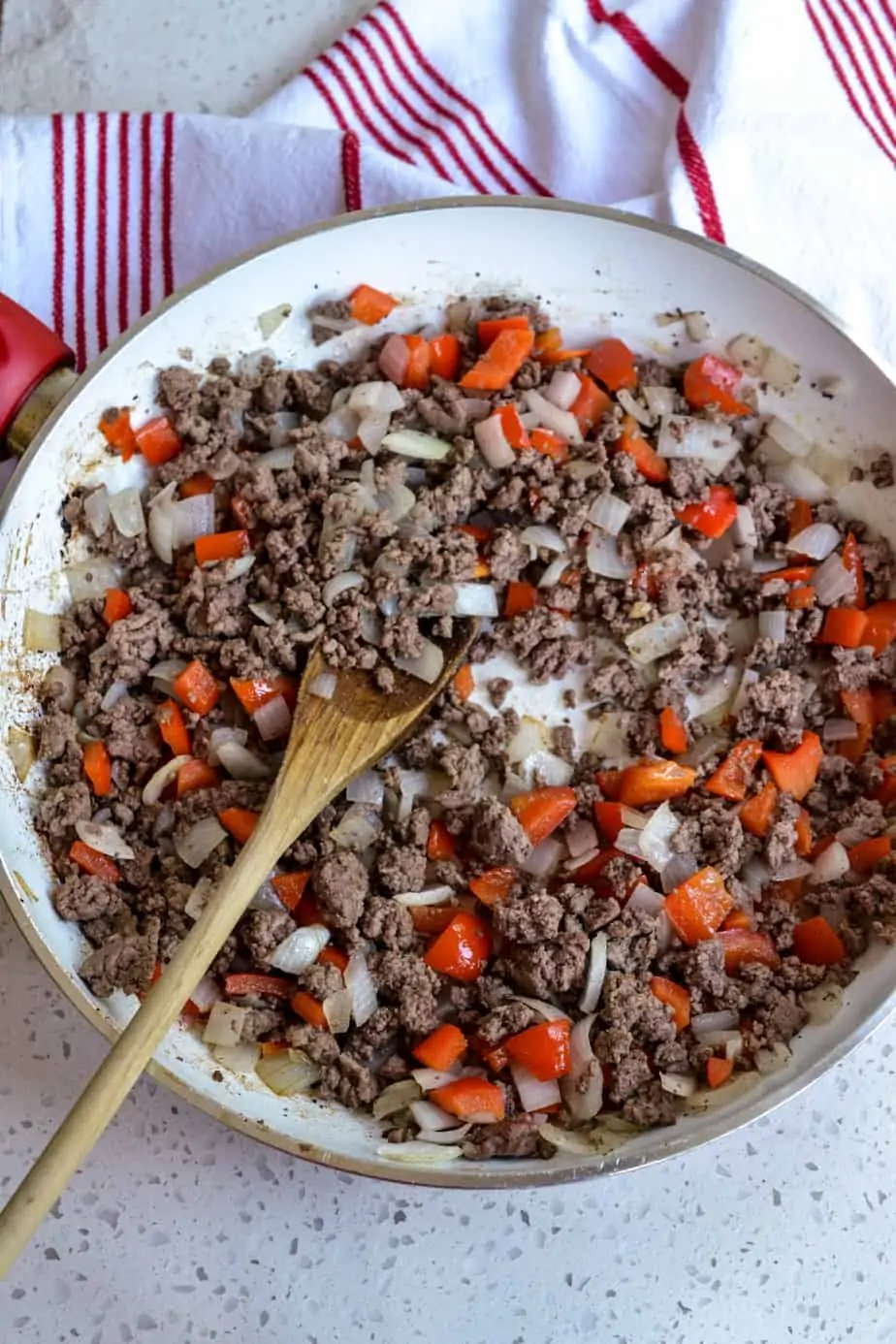To start Cuban Picadillo brown the ground beef. Then add the onion and red bell pepper.