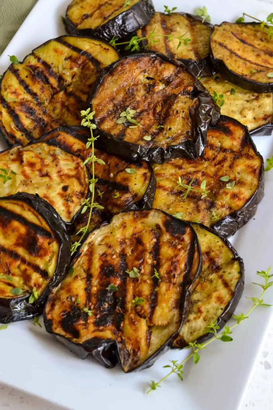 Grilled eggplant on a white plate.