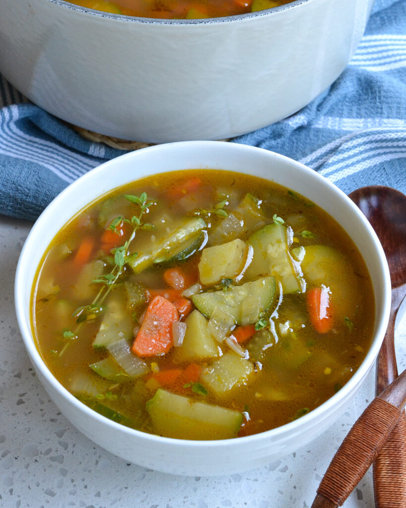 A white bowl full of zucchini vegetable soup.