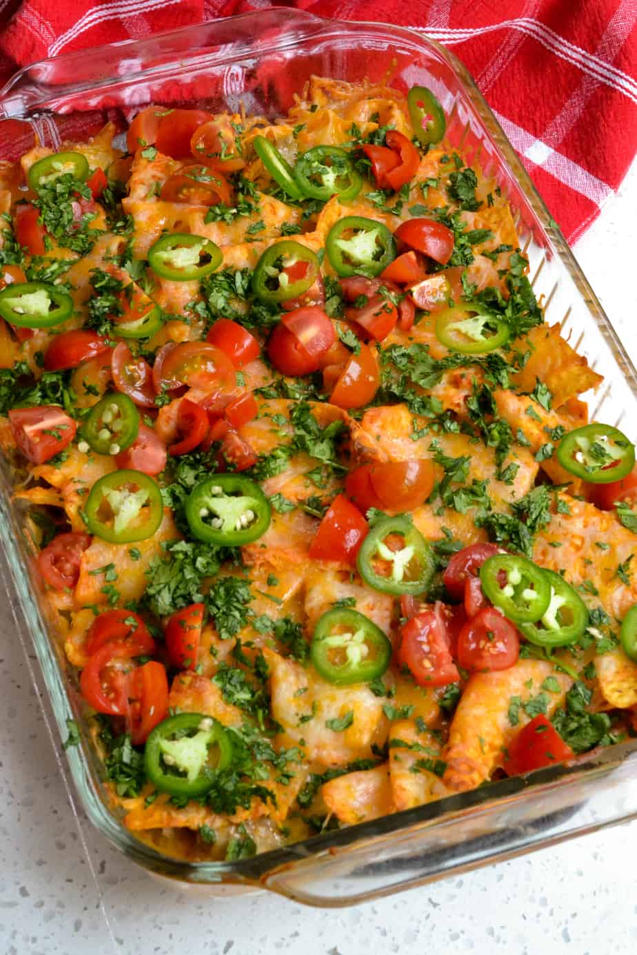Nacho Cheese Doritos Casserole topped with cilantro, tomatoes, and jalapenos