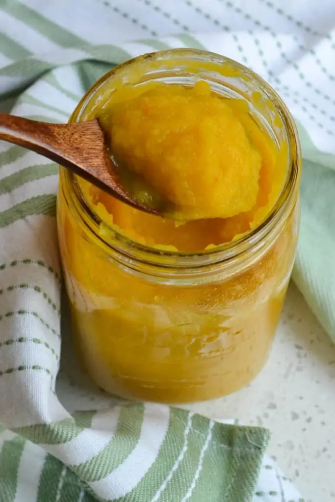 A wooden spoon full of pumpkin puree. 