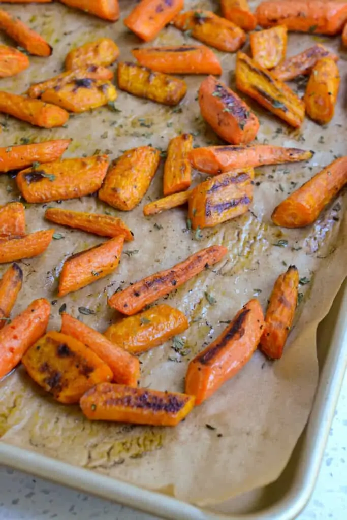 A parchment paper covered baking with roasted carrots. 