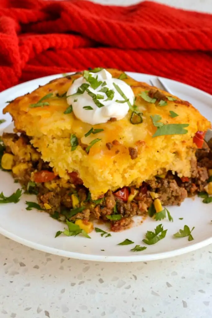 Easy tamale pie with seasoned ground beef, tomatoes, and onions all topped with a cornbread crust. 