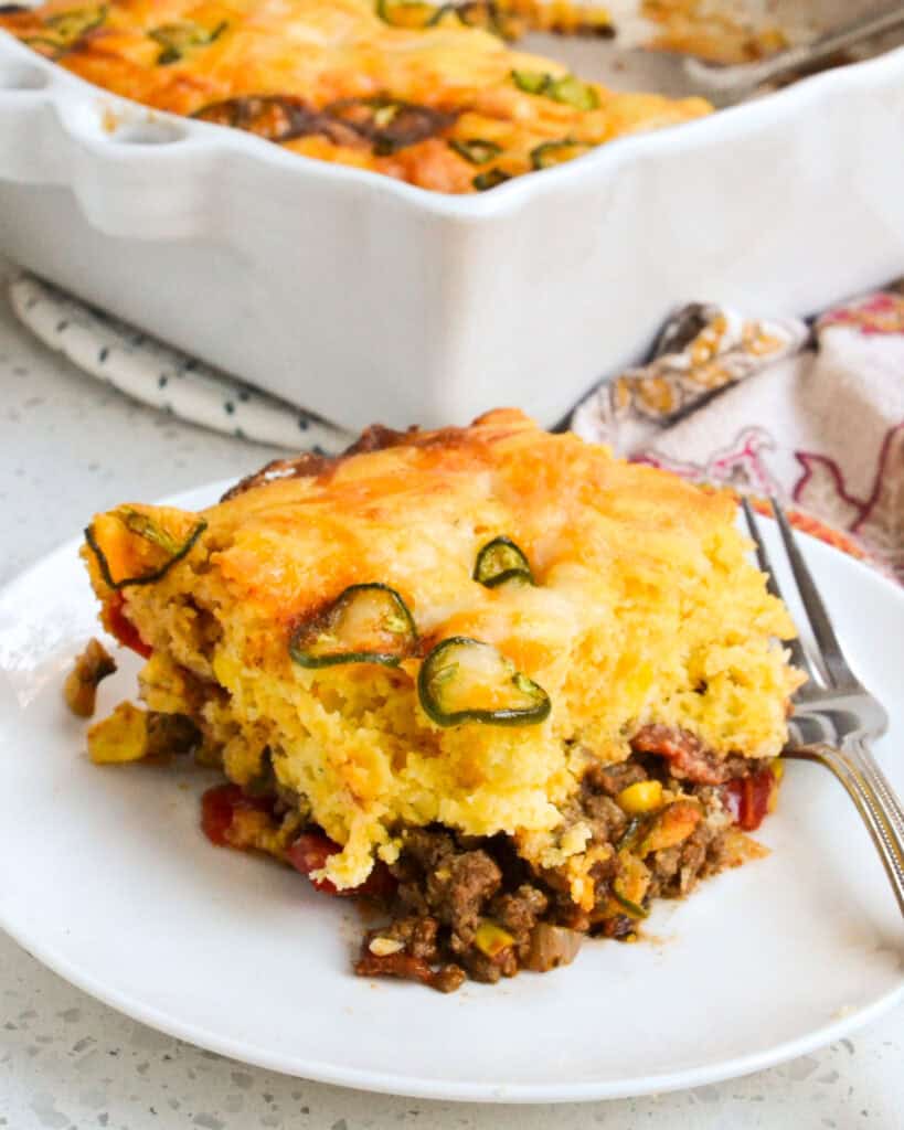 Easy tamale pie with seasoned ground beef, tomatoes, and onions all topped with a cornbread crust.