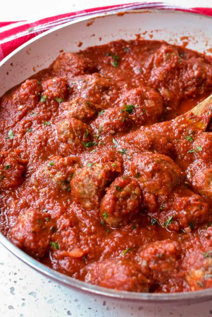 A skillet with homemade Italian meatballs simmered in fresh marinara sauce. 