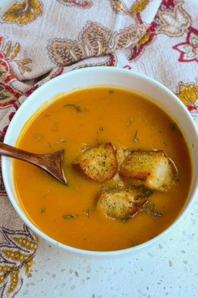 A bowl of butternut squash soup topped with homemade croutons.  