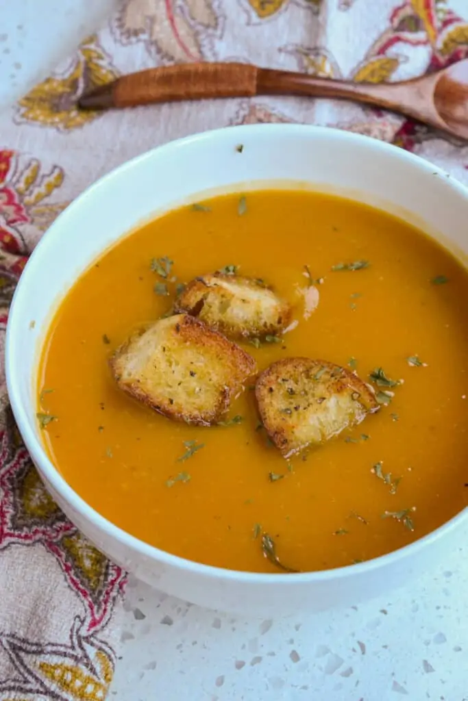 Homemade butternut squash soup topped with parsley and croutons. 