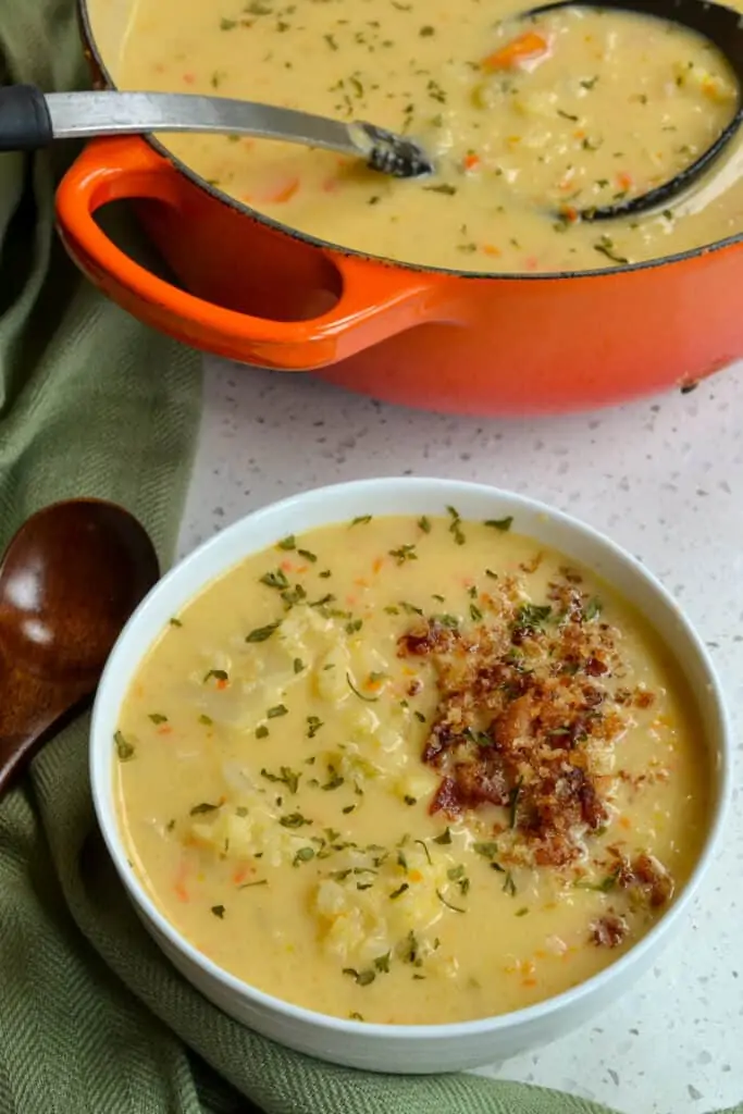 Cheesy Cauliflower soup combines onions, carrots, celery, garlic, and cauliflower in a lightly seasoned cheesy broth topped with bacon and buttery breadcrumbs. 