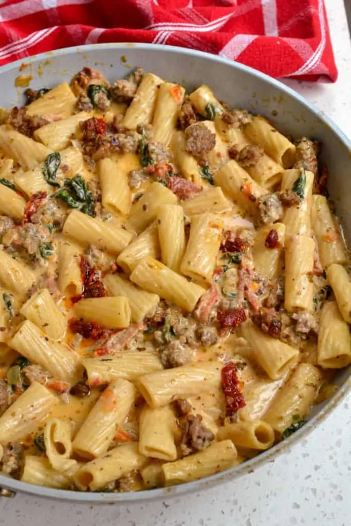A skillet full of creamy Italian Sausage Pasta with sundried tomatoes and spinach. 