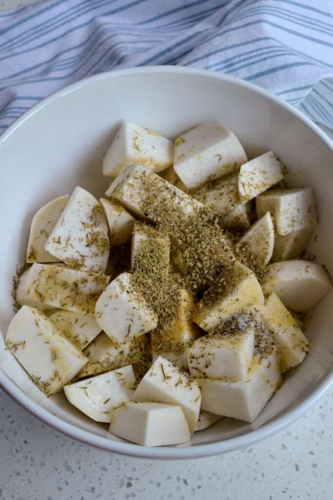 Place the cut turnips in a bowl with dried herbs, salt, and pepper. 